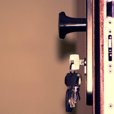 key in a keyhole about to open a door. Buy a house after putting your financial house in order.